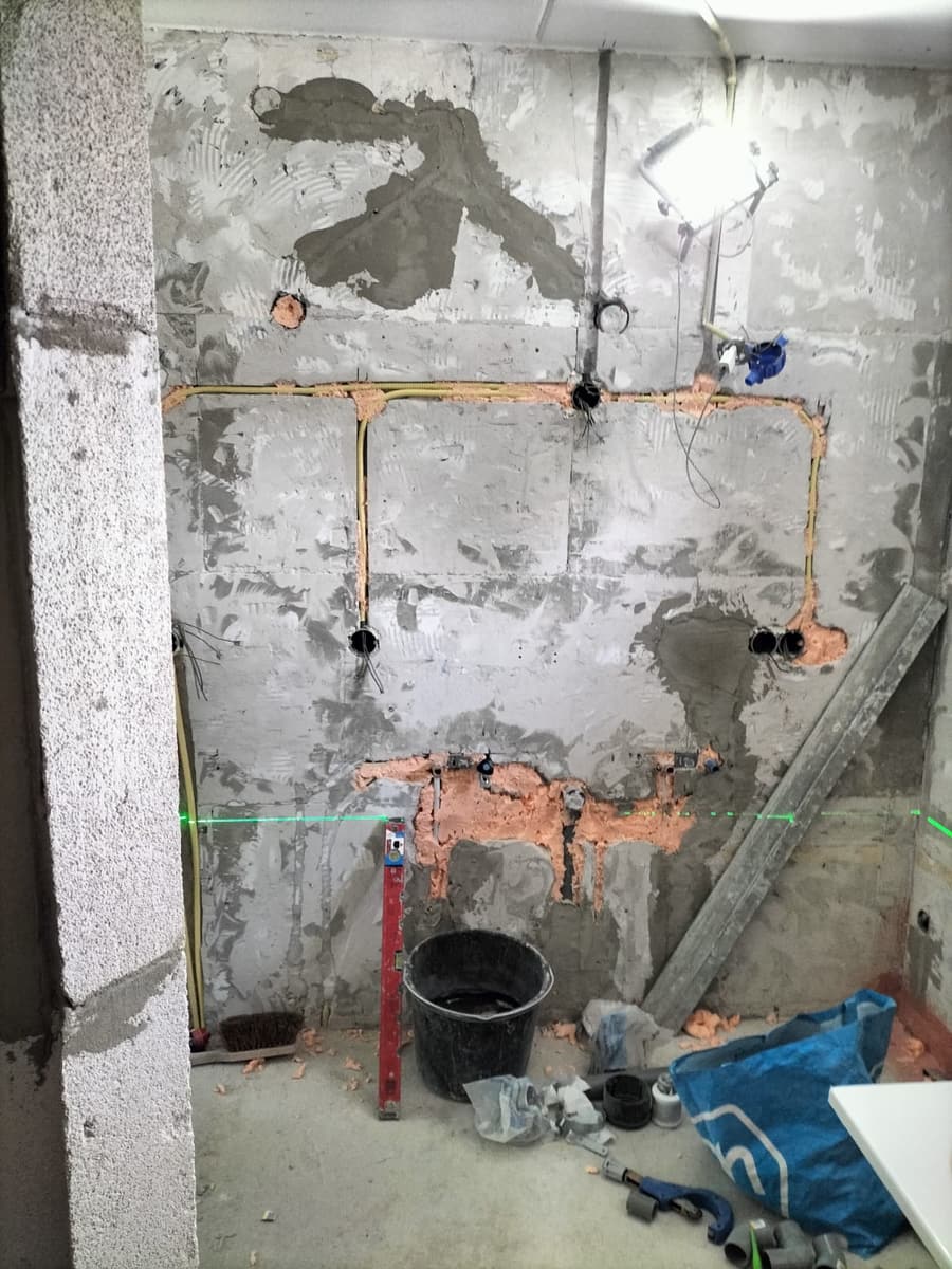 Nieuwe koperen leidingen in de gestripte wand